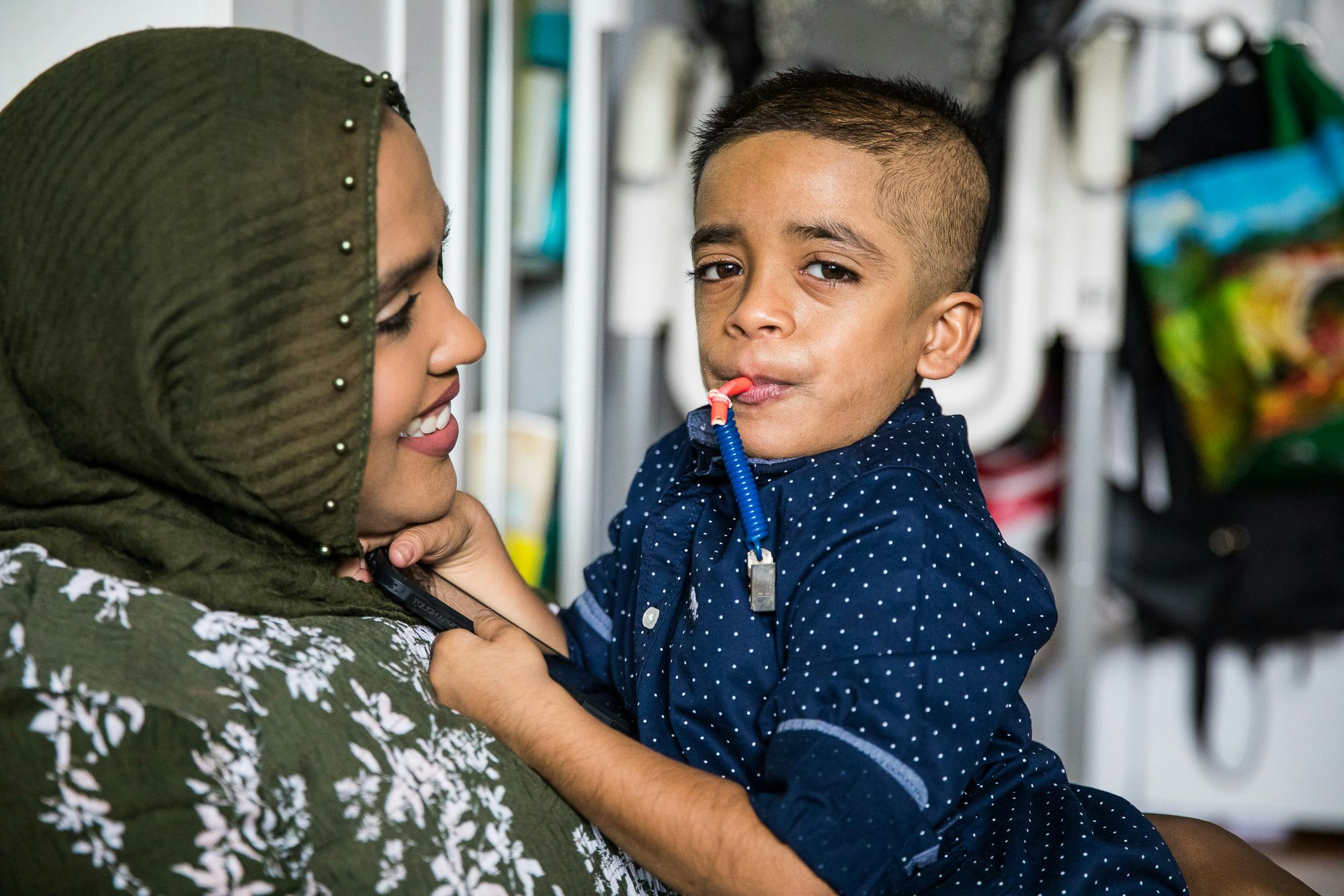 A mother holding her son who has Nicolaides-Baraitser Syndrome