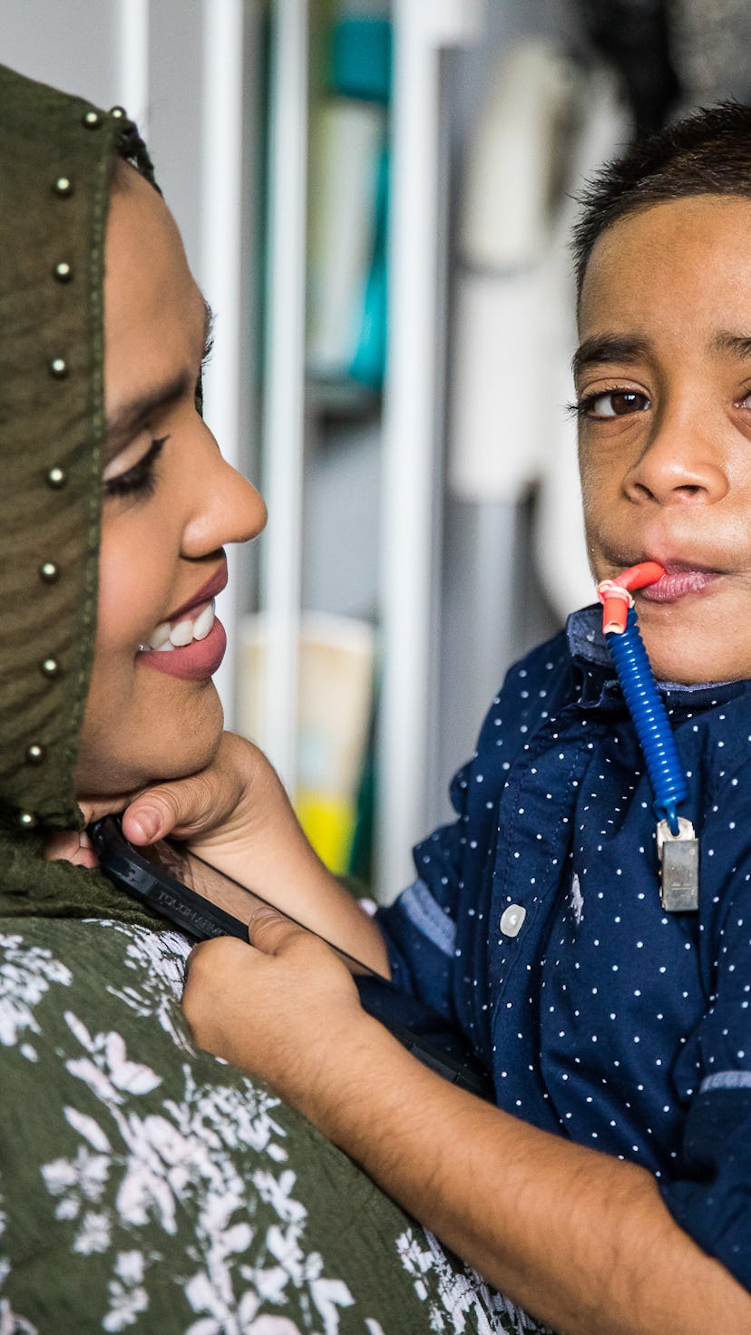 A mother holding her son who has Nicolaides-Baraitser Syndrome