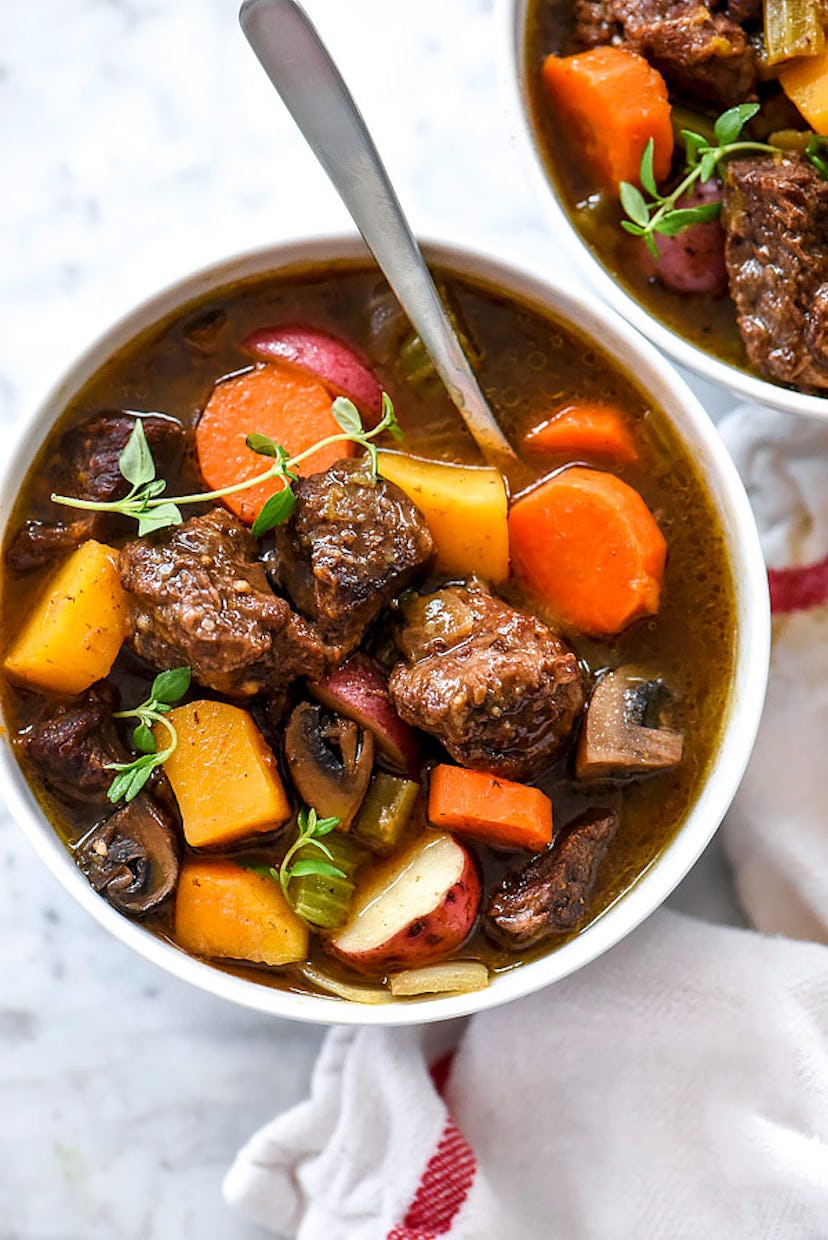 close up of spoon scooping bowl of butternut squash beef stew