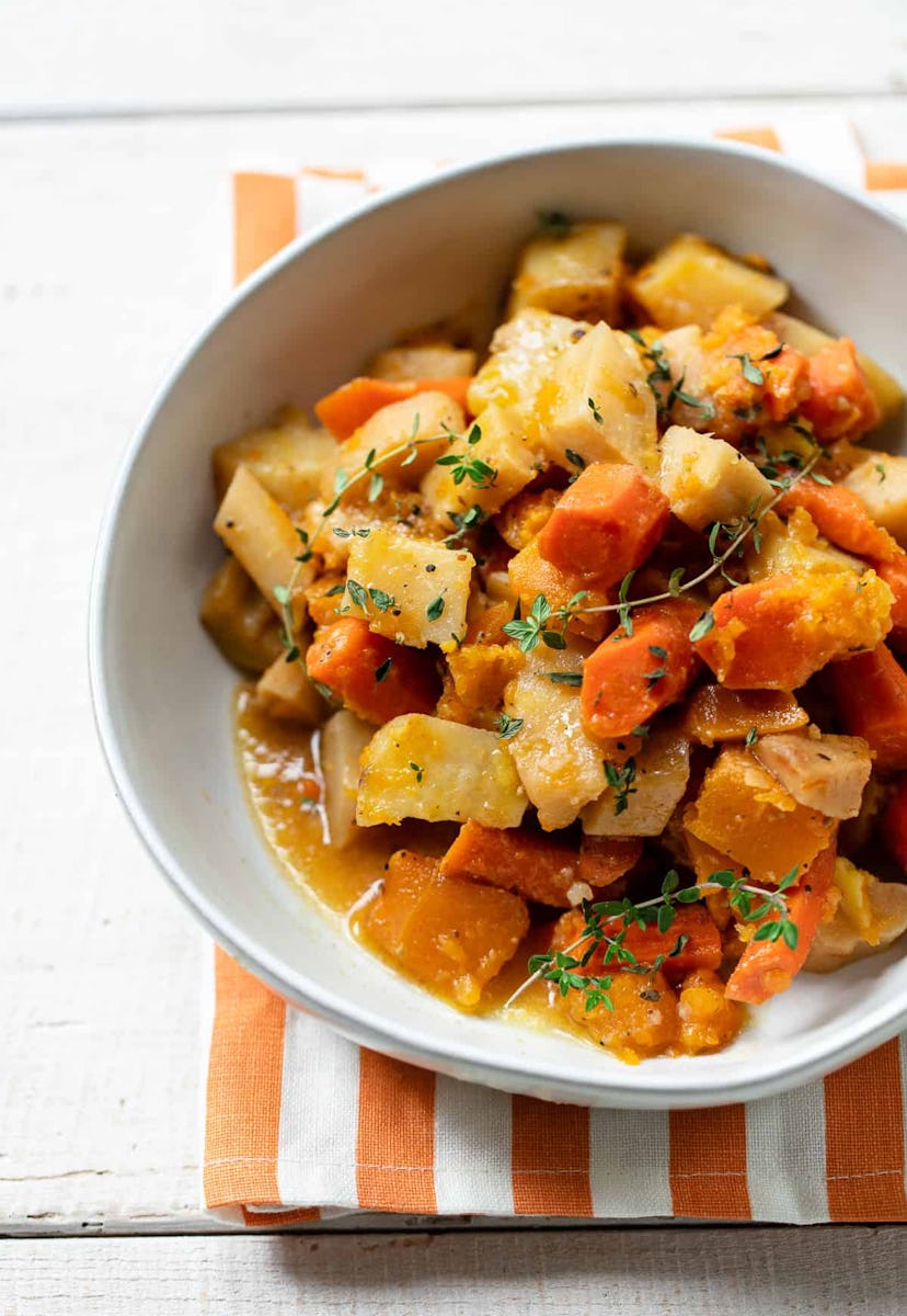cooked carrots, sweet potatoes, yukon gold, parsnips and butternut squash in a white bowl on top of ...