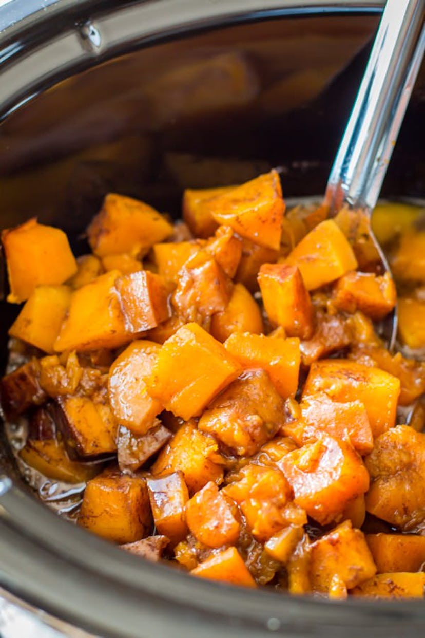 Close up of pot full of butternut squash with spoon scooping 
