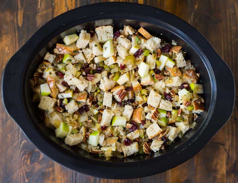 Crock pot full of chopped bread, apples, cranberries and walnuts