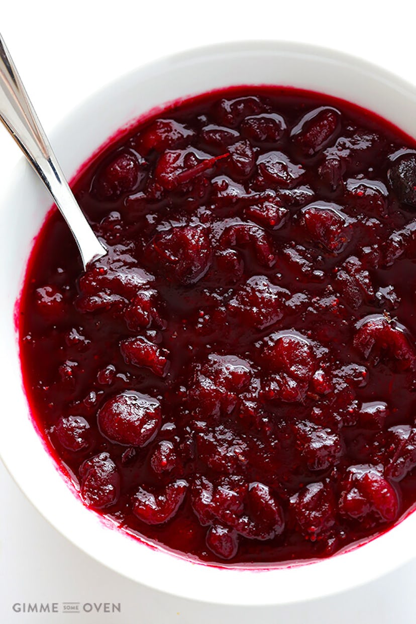 White bowl with cranberry sauce and spoon in it