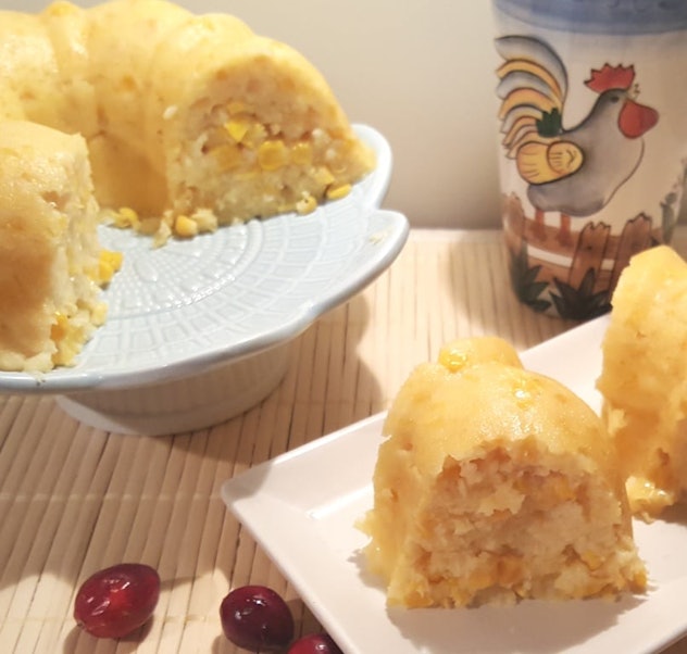 corn bread with actual corn inside the pieces on white dishes on table decorated with cranberries 