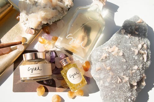 Three Crystal-Infused Beauty Products next to large and small crystal rocks