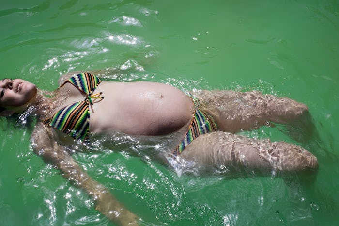 A pregnant woman resting and floating on the surface of a lake