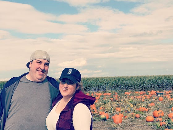 Jessie Glockling and her husband posing in a pumpkin field