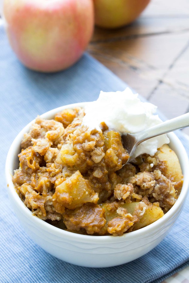 Thanksgiving Desserts: An apple pie filling mixed with a crumble in a bowl with whipped cream on top