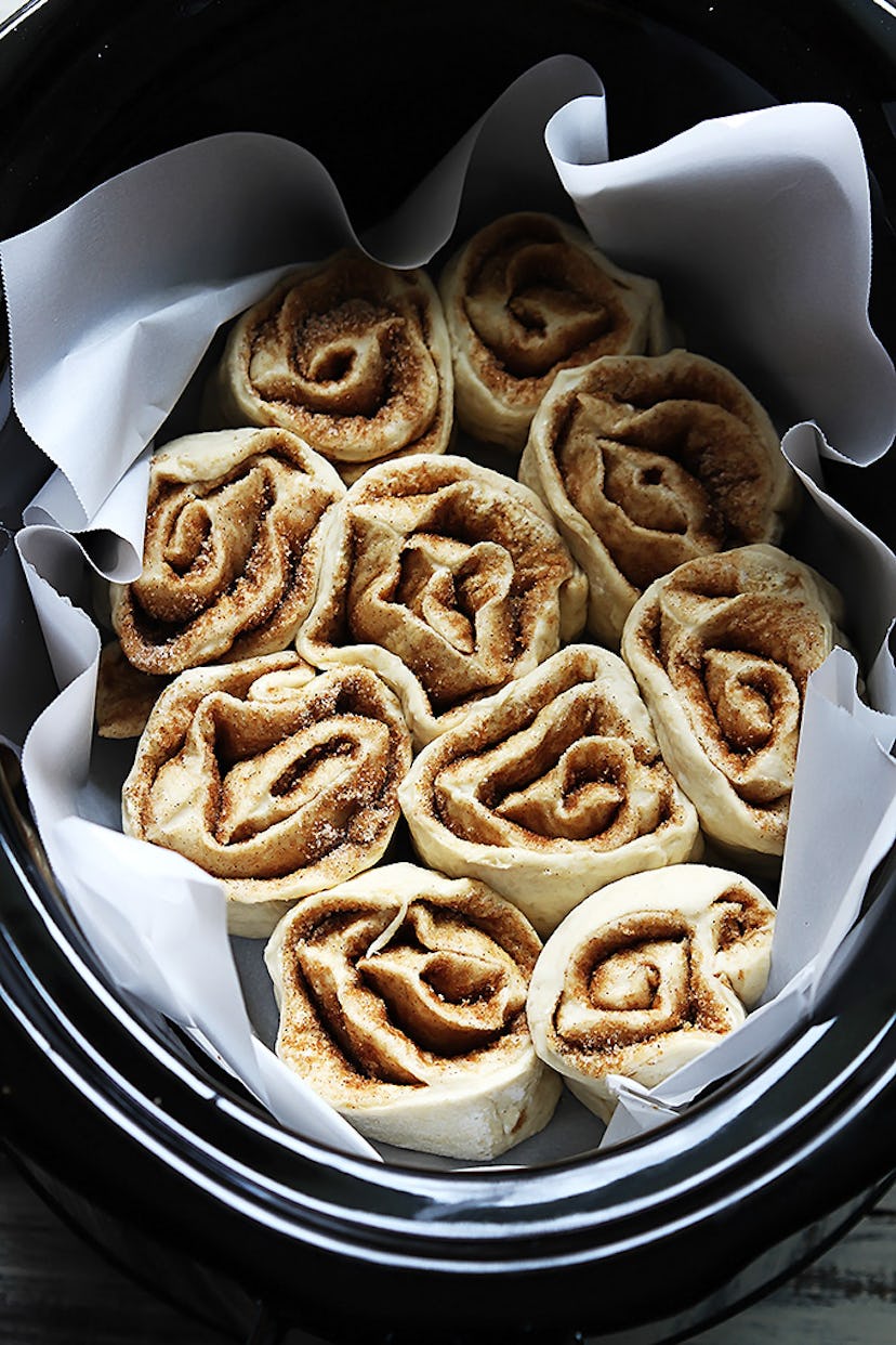 slow cooker full of unbaked cinnamon rolls on paper