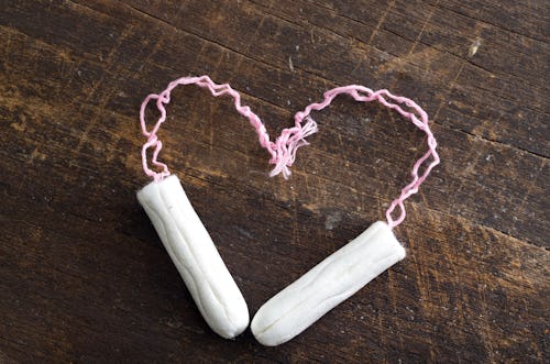 Two tampons forming a heart on a wooden table