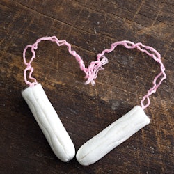 Two tampons forming a heart on a wooden table