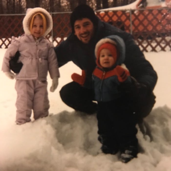 A dad with his children in the snow ready to go hand out treats to their neighbors