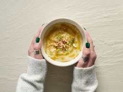 Female hands holding a bowl of cauliflower soup