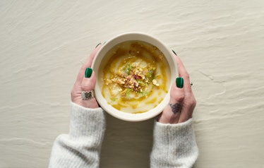 Female hands holding a bowl of cauliflower soup