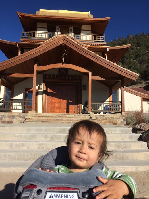 Ambika Samarthya-Howard's son in front of the Buddhist temple on a sunny day.