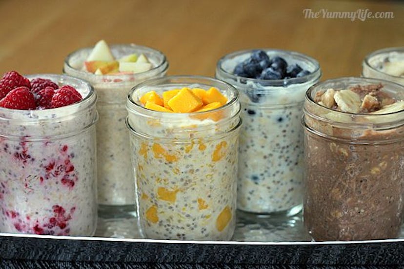 metal tray full of clear jars of overnight oats in yogurt with different fruits in each jar