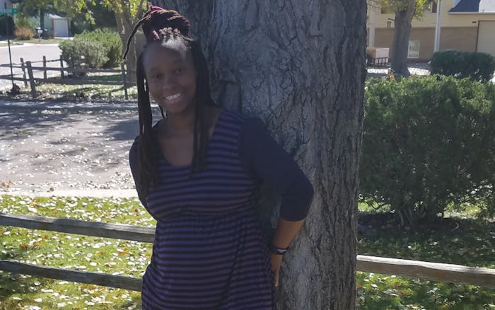 A. Rochaun Meadows-Fernandez posing next to a tree in a black dress