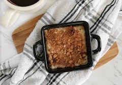 Coffee cake served in a small greased dish with a dish cloth beneath