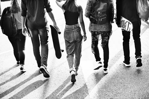 5 gen z members walking together down a street