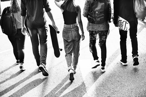5 gen z members walking together down a street