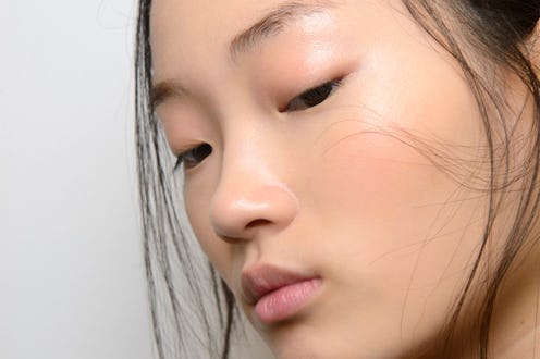 A close-up of a model's face who uses collagen supplements and has clear skin