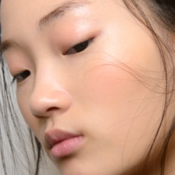 A close-up of a model's face who uses collagen supplements and has clear skin