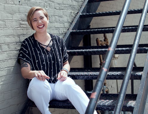 A blonde and short-haired girl with PTSD sitting on stairs and laughing