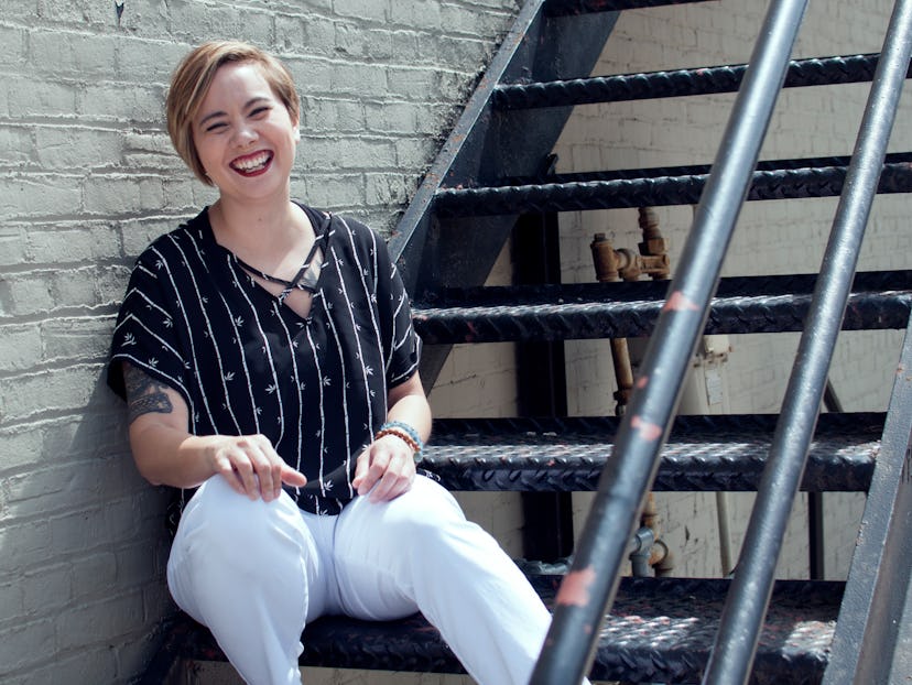 A blonde and short-haired girl with PTSD sitting on stairs and laughing