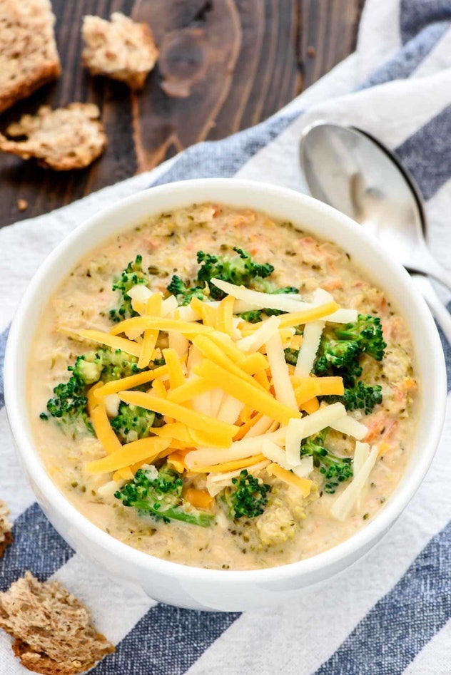 Bowl of broccoli cheddar soup with chunks of broccoli and shredded cheese on top