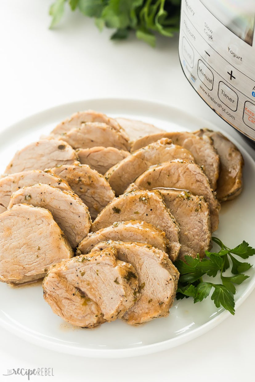 plate of sliced pork tenderloin next to pressure cooker