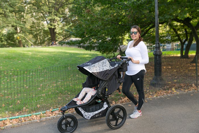 A woman walking her daughter in a stroller