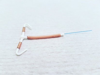 a copper IUD  set on a white table
