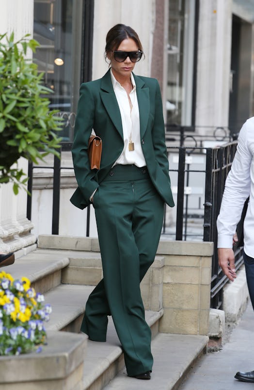 Victoria Beckham wearing a green two-piece suit.