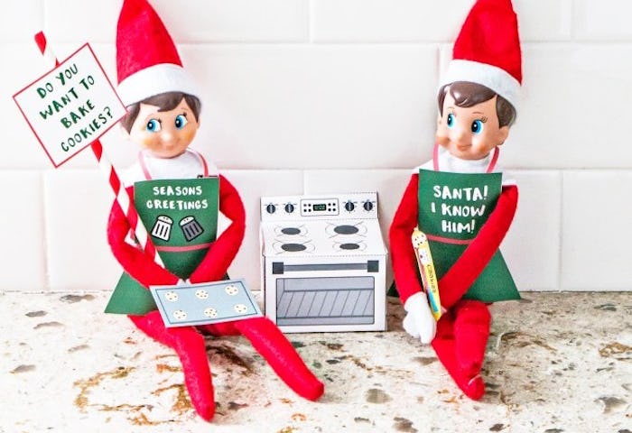 two baking elves posing with a print out oven, elf on the shelf printable props