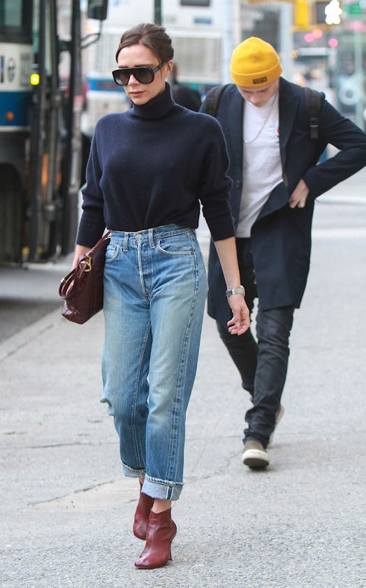 Victoria Beckham wearing high-waisted jeans and a turtleneck.