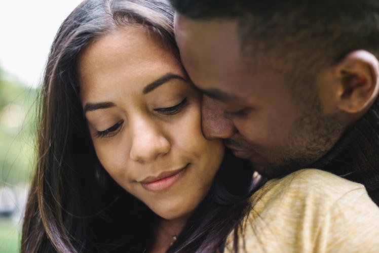 A man hugging and kissing his girlfriend