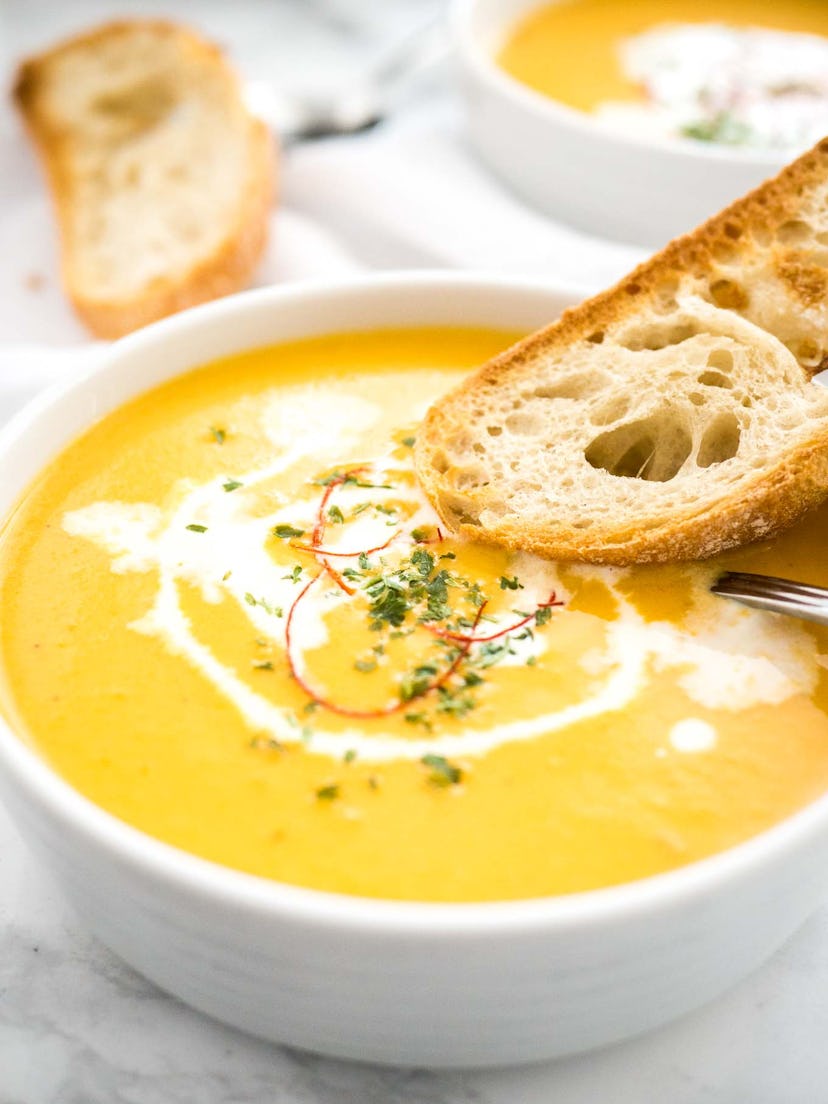 Carrot Soup served in a bowl with bread