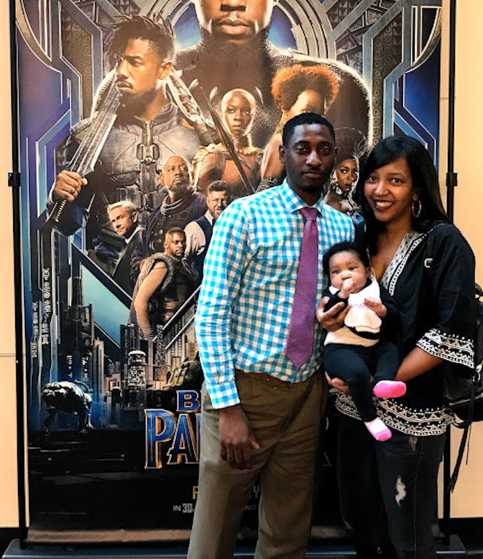 Parents posing with their kid at the Black Panther showing in the cinema