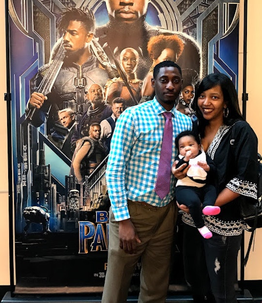 Parents posing with their kid at the Black Panther showing in the cinema