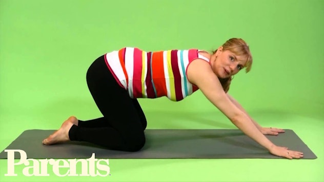 Pregnant woman doing yoga child's pose.