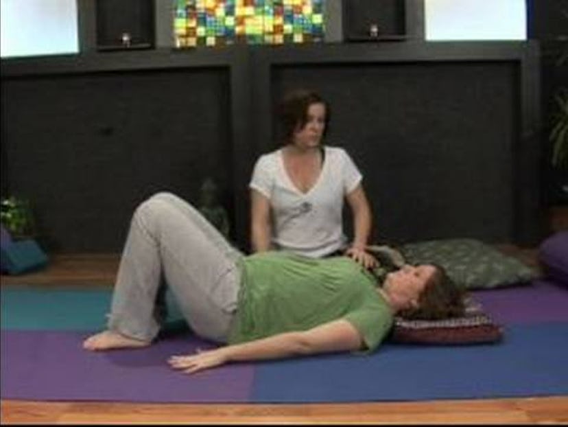 Pregnant woman doing yoga supported bridge.