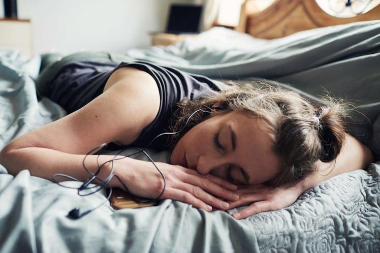 A girl laying on her stomach in bed, sweating out a cold