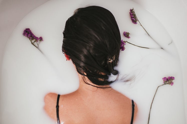 A woman taking a bath with flowers in it as it is the easiest and most relaxing way to stop a headac...