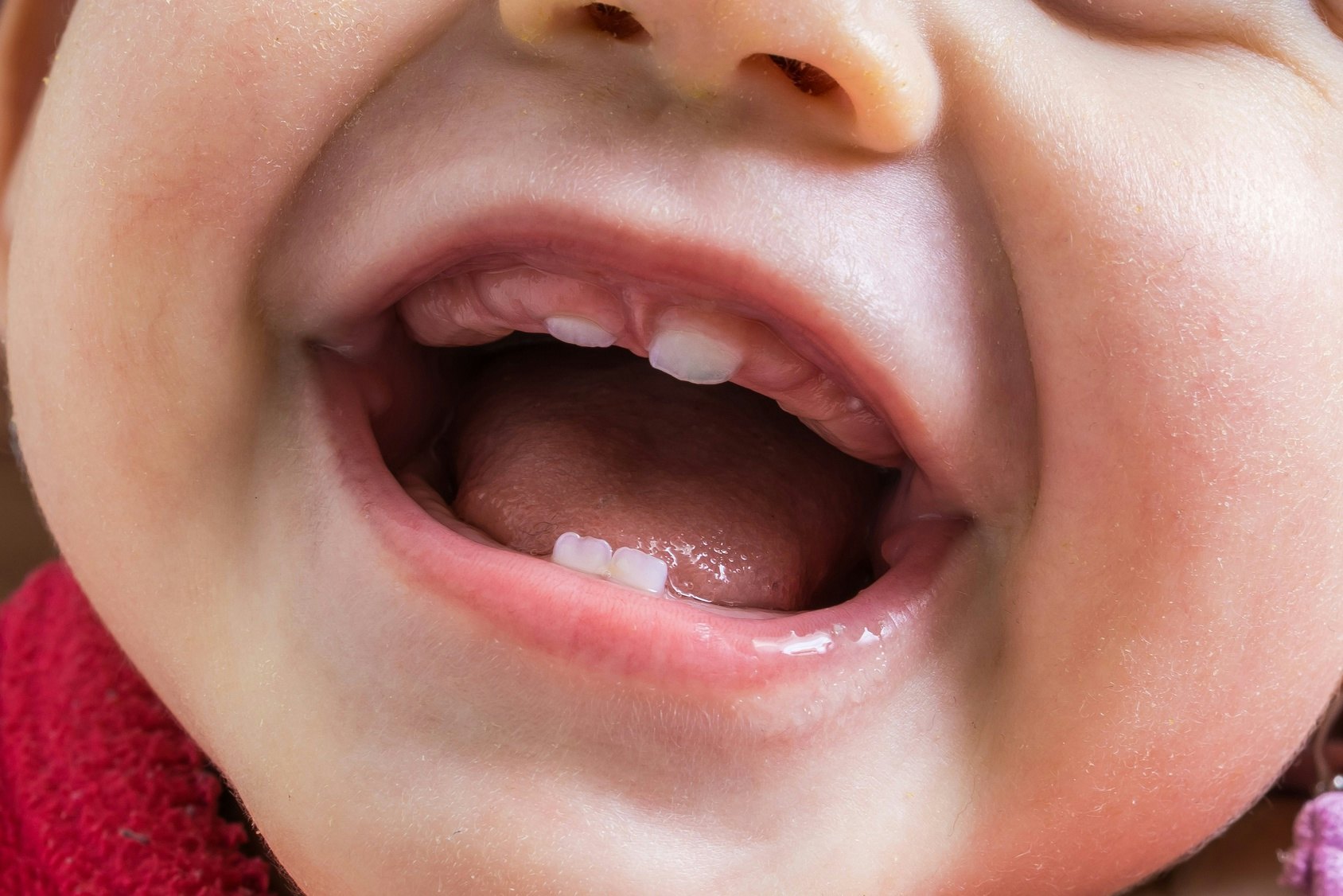 baby cutting first tooth