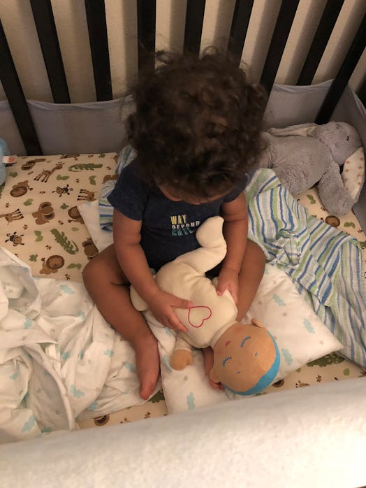 A toddler holding her Lulla Doll sleep companion