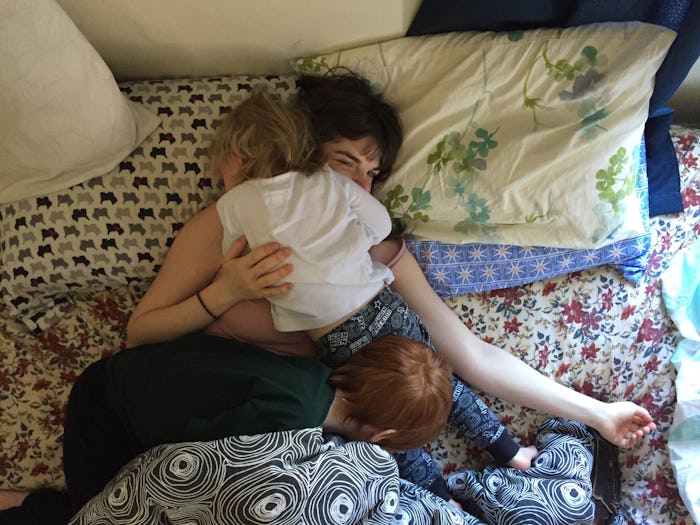 A mom in a bed, co-sleeping with her child on her chest