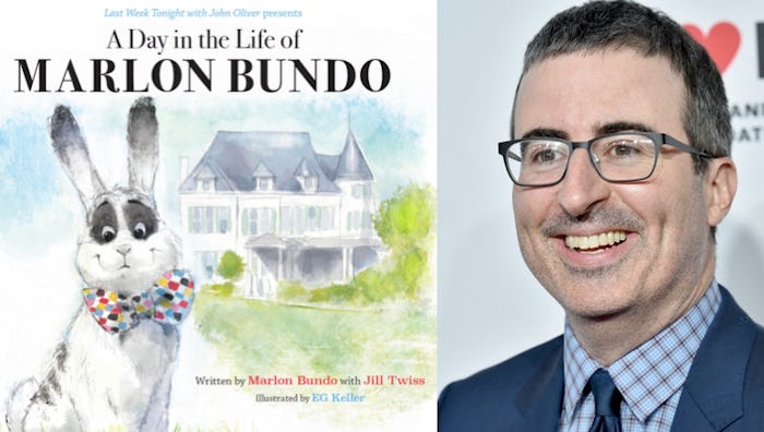 John Oliver next to the cover of his book a day in the life of marlon bundo