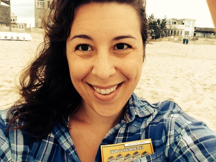 A woman smiling at the camera while taking a selfie on the beach