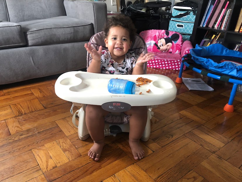 A toddler sitting in a feeding chair