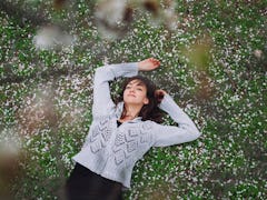 Woman lies in the grass, thinking about her breakup.